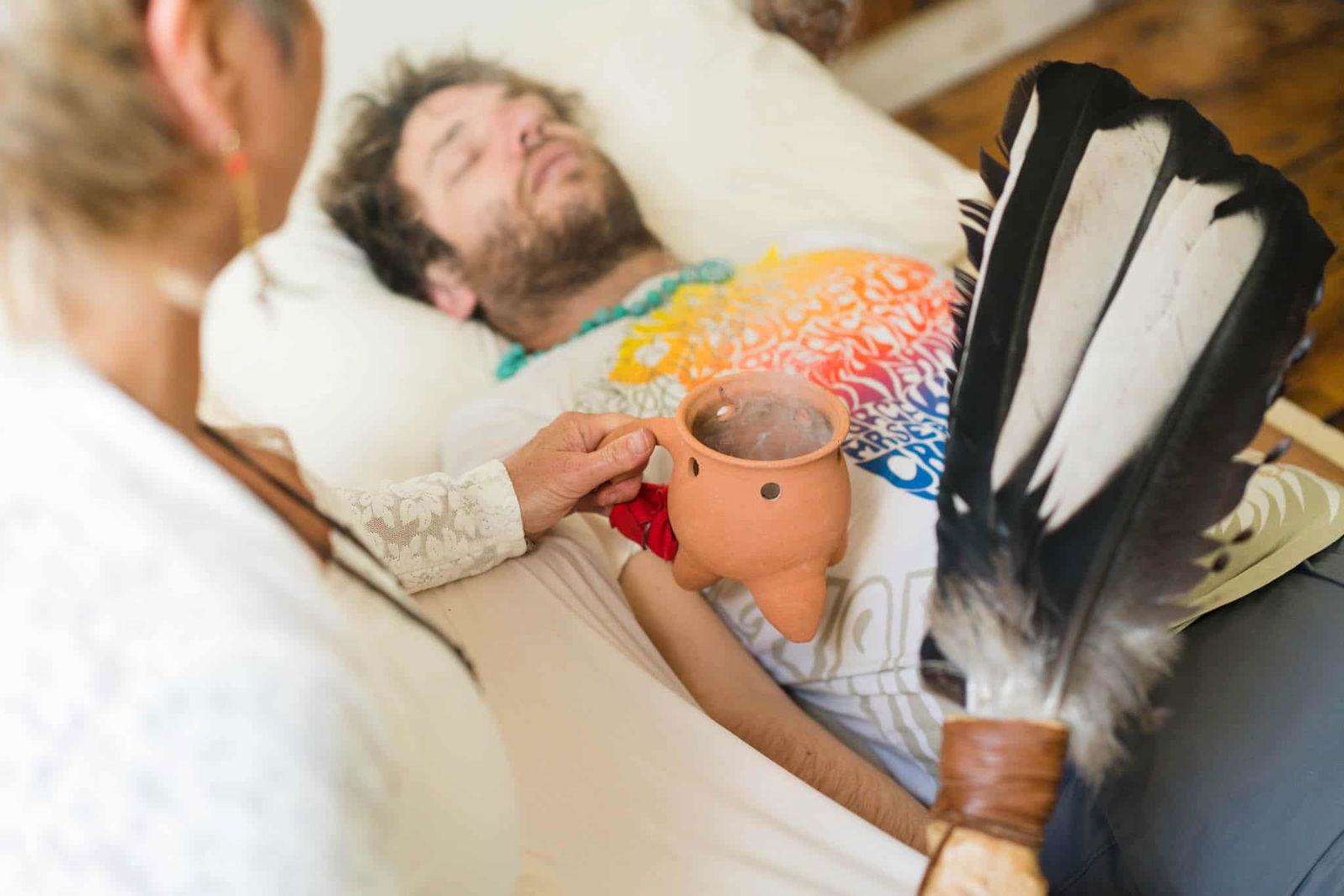 Sue Holmes completing a healing session with someone lay down next to her